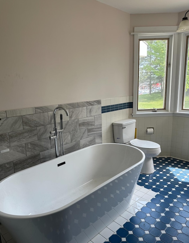 bathroom with tile walls, toilet, and tile floors