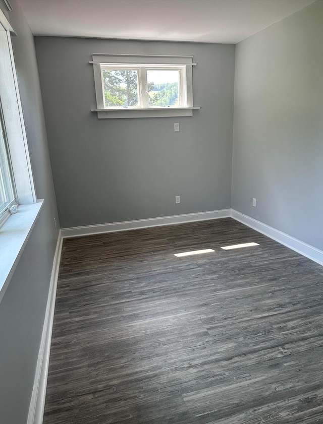 unfurnished room with dark hardwood / wood-style flooring