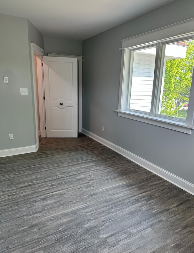 unfurnished room with dark wood-type flooring