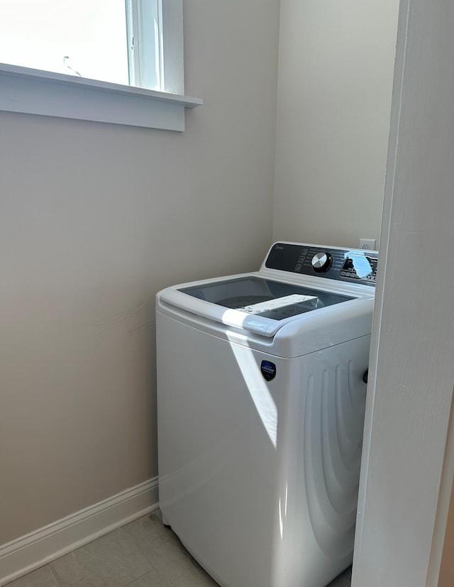 clothes washing area featuring separate washer and dryer and light tile floors