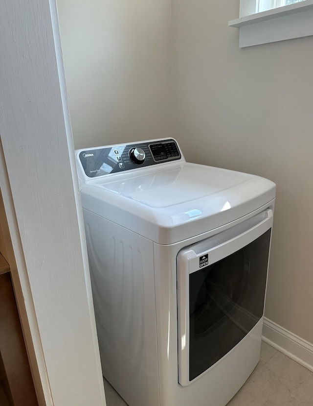 clothes washing area with light tile floors and washer / dryer