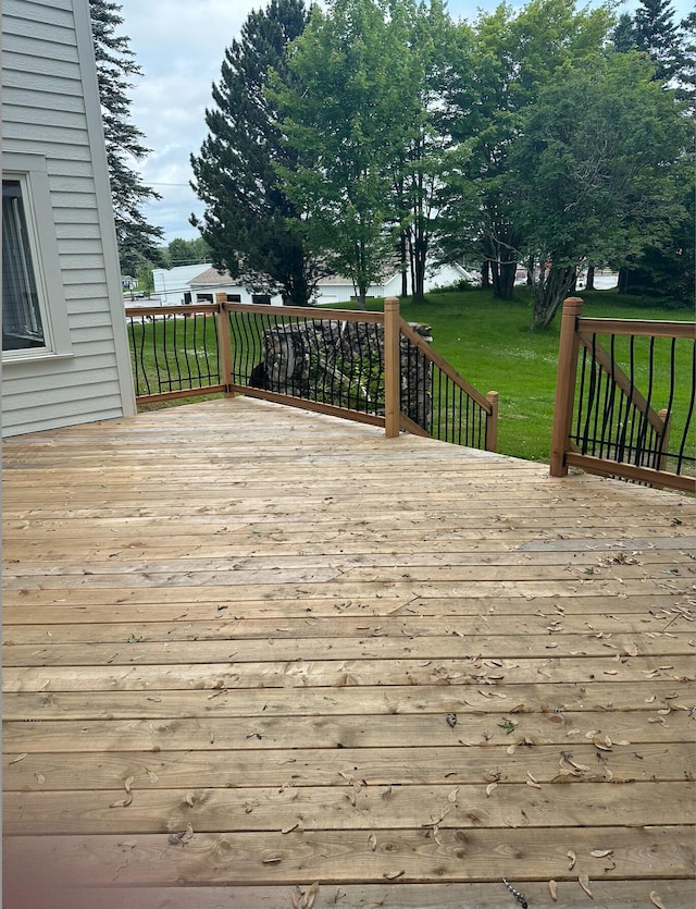 wooden terrace featuring a yard