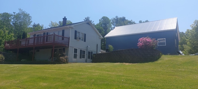 back of property featuring a wooden deck and a yard