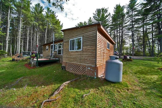 view of side of home featuring a deck and a yard