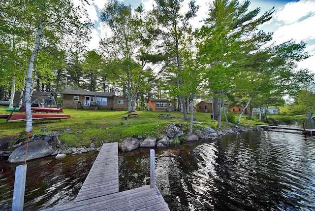 dock area featuring a lawn and a water view