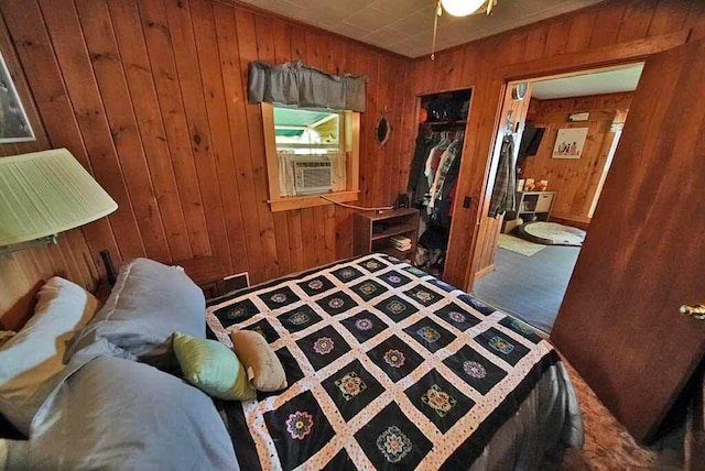 carpeted bedroom featuring wood walls, connected bathroom, and a closet