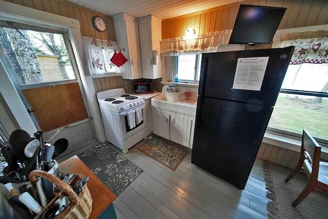 kitchen featuring light hardwood / wood-style flooring, white cabinetry, and black appliances