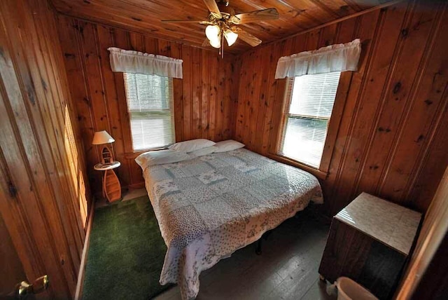 bedroom featuring wooden ceiling, multiple windows, wooden walls, and ceiling fan