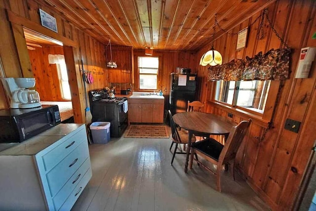 kitchen featuring wooden walls, decorative light fixtures, wood ceiling, and washer / dryer