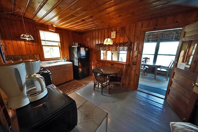 dining space with wood ceiling, wood walls, and hardwood / wood-style flooring