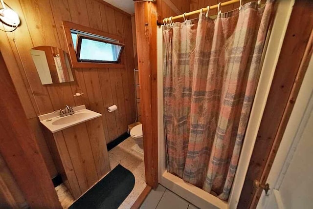 bathroom featuring oversized vanity, toilet, and wood walls