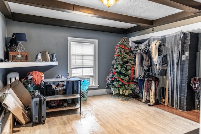 walk in closet featuring wood-type flooring and beam ceiling