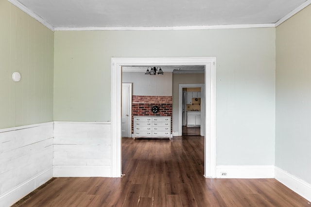 hallway featuring dark wood-type flooring, wood walls, and ornamental molding