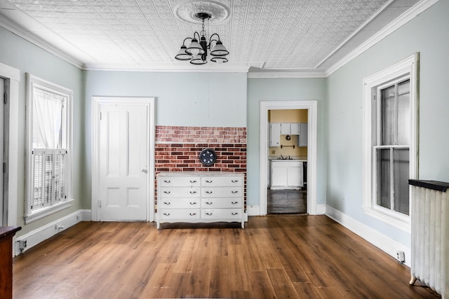 interior space featuring ornamental molding, hardwood / wood-style floors, and a notable chandelier