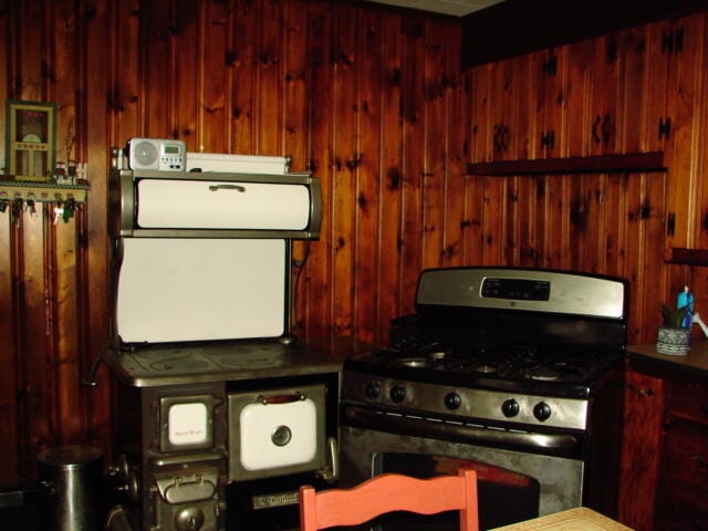 kitchen featuring wood walls and stainless steel gas range