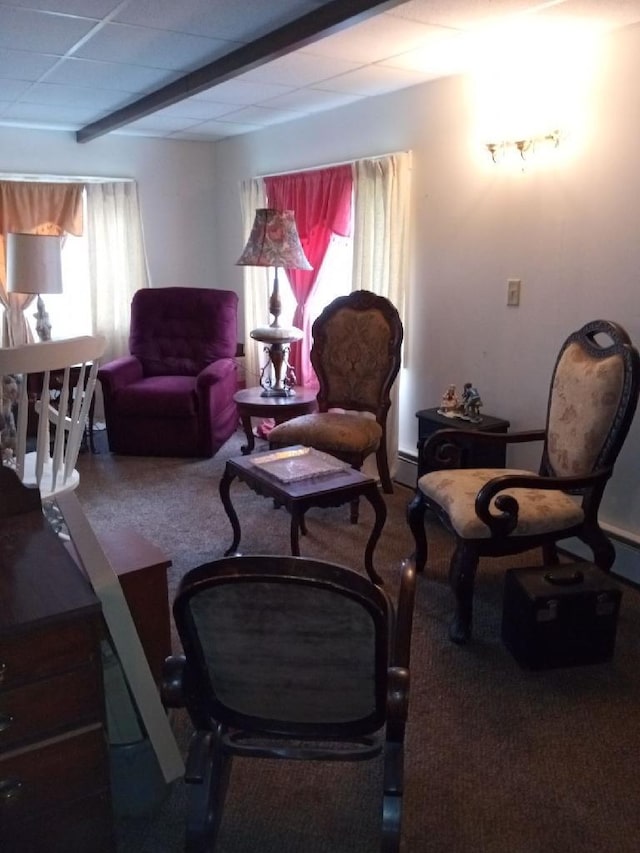 living room featuring beam ceiling, a chandelier, and a baseboard heating unit