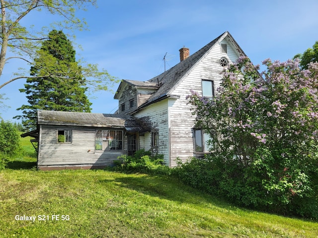 rear view of property featuring a yard