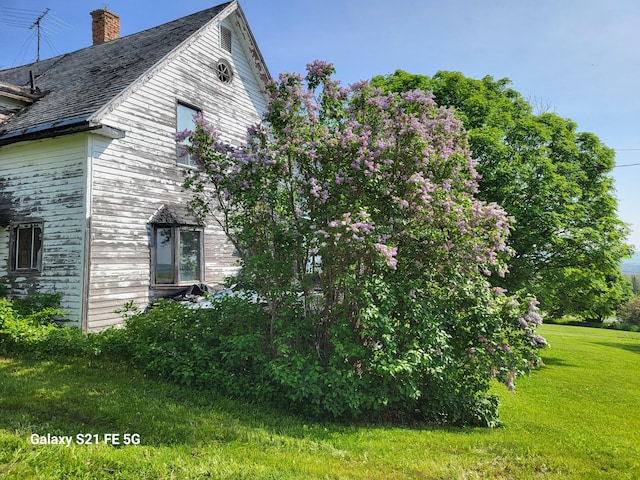 view of side of property with a lawn