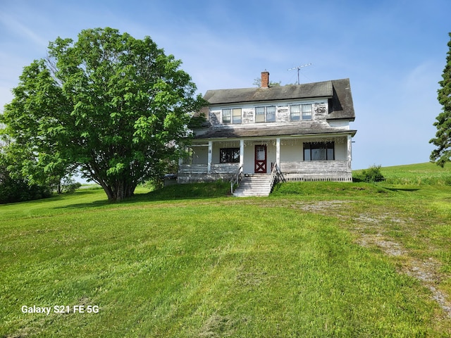 view of front of home featuring covered porch and a front lawn