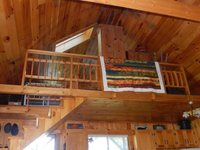 interior space featuring wooden walls, a skylight, and high vaulted ceiling