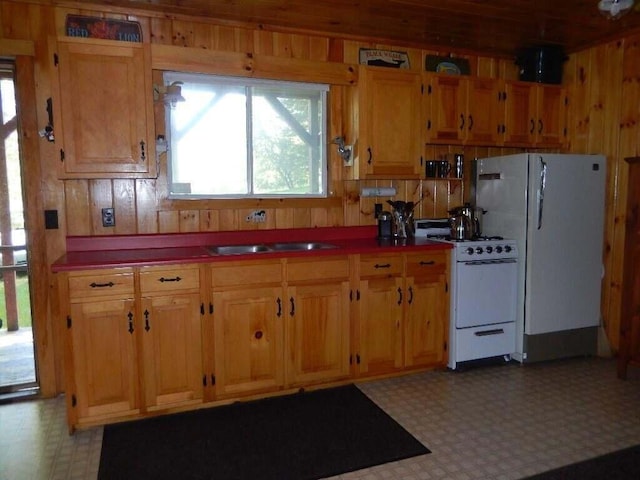 kitchen featuring white appliances, sink, light tile floors, and plenty of natural light