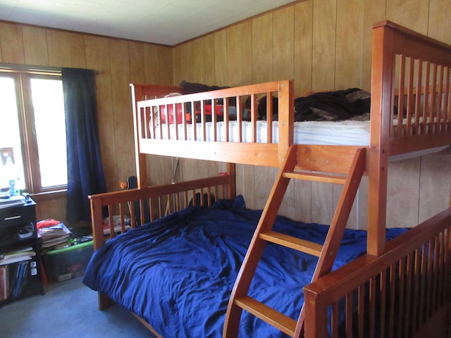 bedroom with carpet floors and wood walls