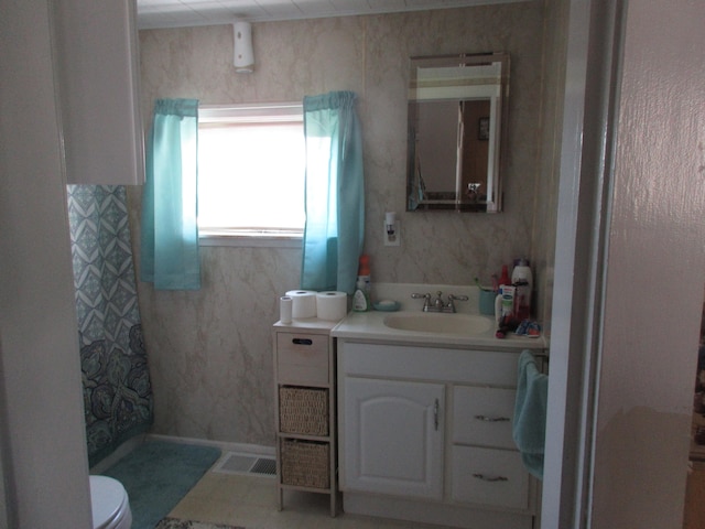 bathroom with tile flooring, toilet, and oversized vanity