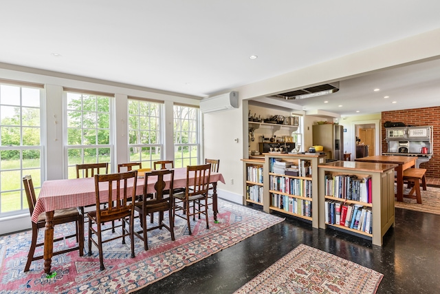 dining room featuring brick wall, a wealth of natural light, and a wall mounted air conditioner