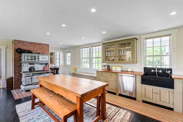 kitchen with plenty of natural light, brick wall, stainless steel dishwasher, and sink