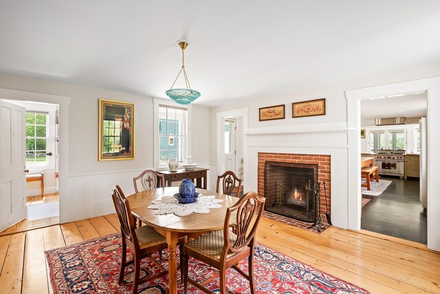 dining space featuring a fireplace and light wood-type flooring