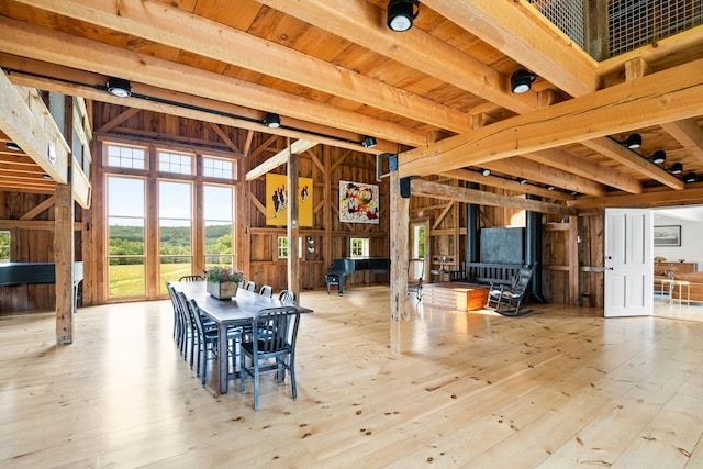 interior space with wooden walls, light hardwood / wood-style floors, and beamed ceiling