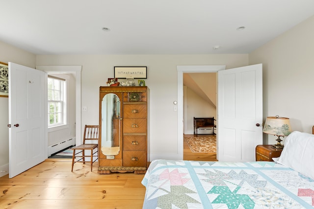 bedroom featuring a baseboard radiator and light hardwood / wood-style floors