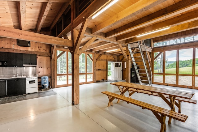 interior space with wooden walls, wooden ceiling, and beam ceiling