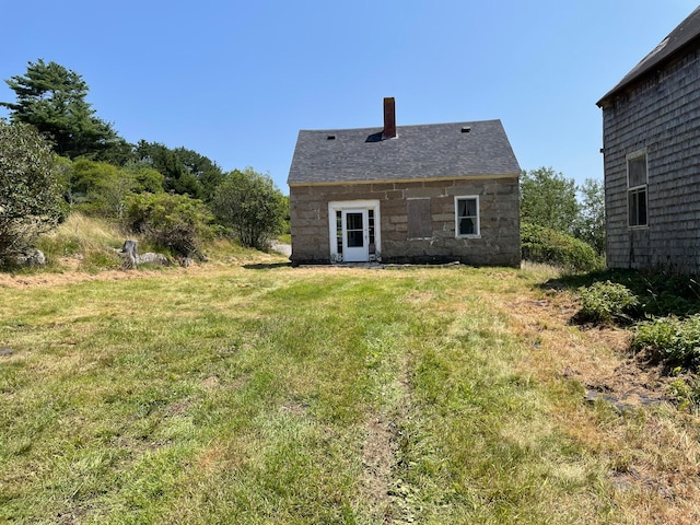 rear view of property featuring a lawn