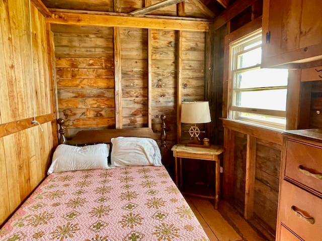 bedroom featuring light hardwood / wood-style flooring and wooden walls