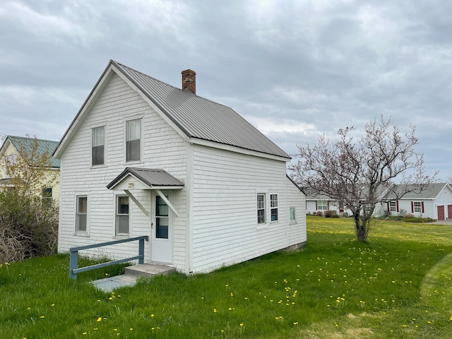 rear view of property with a lawn