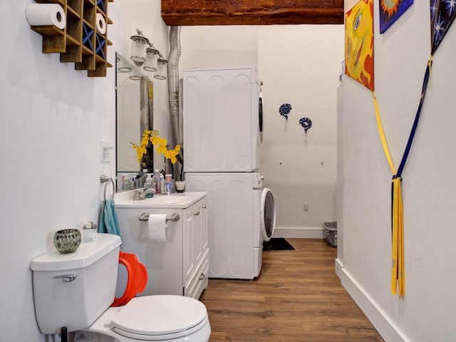 bathroom featuring toilet, stacked washer / drying machine, beamed ceiling, vanity, and hardwood / wood-style flooring