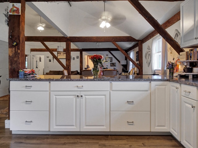 kitchen featuring ceiling fan, dark stone counters, dark hardwood / wood-style flooring, white cabinets, and lofted ceiling