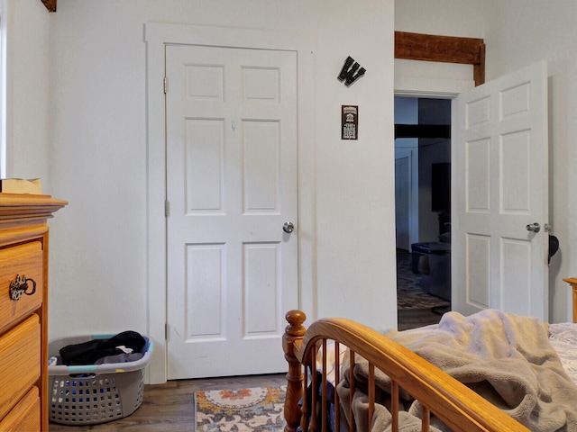 bedroom with beamed ceiling and wood-type flooring