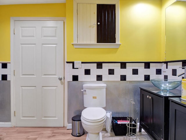 bathroom featuring toilet, wood-type flooring, and vanity