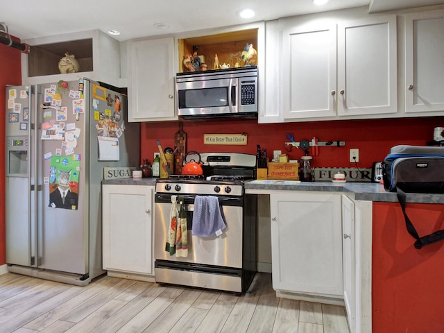 kitchen featuring white cabinets, light wood-type flooring, and appliances with stainless steel finishes