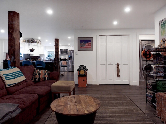 living room featuring dark wood-type flooring and stacked washer and dryer