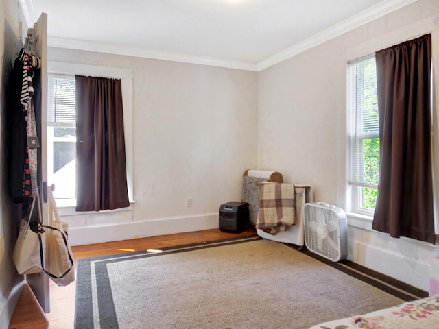 bedroom with ornamental molding and light hardwood / wood-style flooring