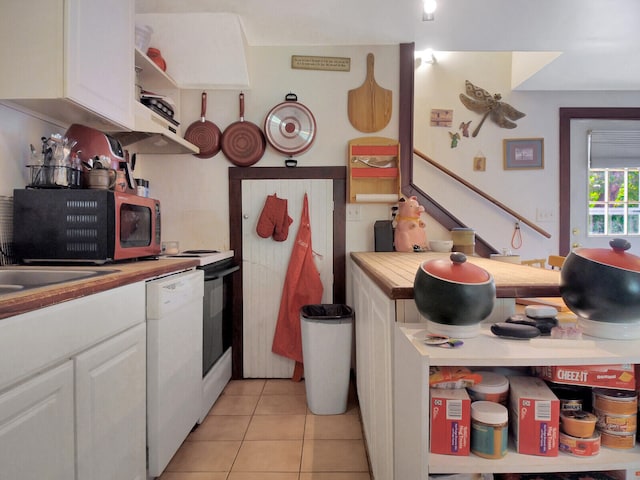 kitchen featuring white cabinets, dishwasher, and light tile patterned floors