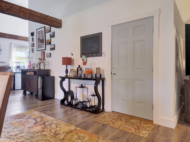 entrance foyer with wood-type flooring, bar area, and beamed ceiling