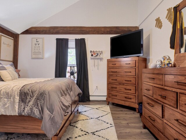 bedroom featuring vaulted ceiling, hardwood / wood-style flooring, and a baseboard radiator