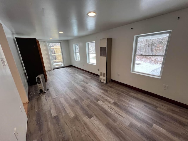 unfurnished living room with hardwood / wood-style flooring and a healthy amount of sunlight