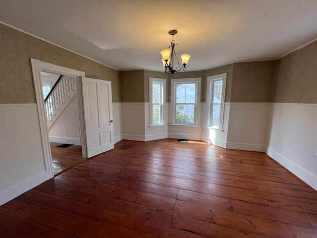 unfurnished dining area featuring dark hardwood / wood-style floors and a chandelier