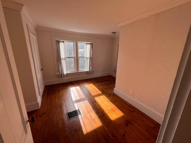 unfurnished room featuring crown molding and dark hardwood / wood-style flooring