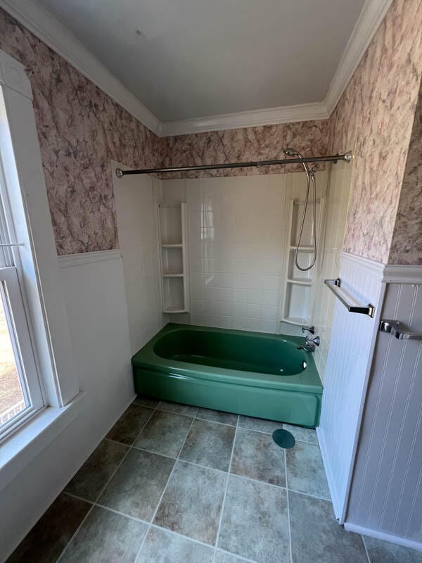 bathroom with ornamental molding and shower / washtub combination